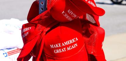 Red baseball caps with words "Make America Great Again" in front.