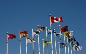 "All the flags of Canada including the provinces and territories blowing proudly in the wind at Canada Place in Vancouver, B.C. Canada"